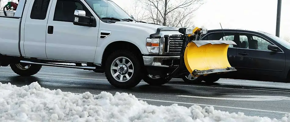 Truck plow removing snow from a commercial parking lot in Noblesville, IN.