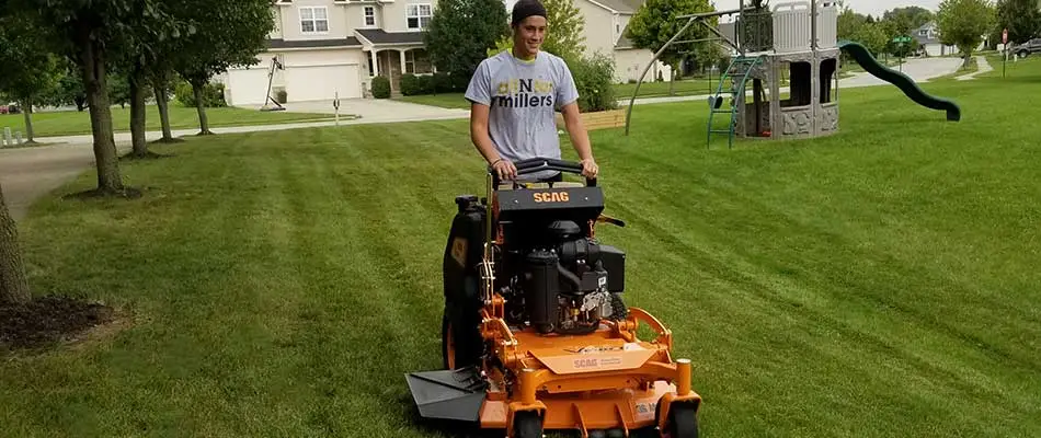 Sprout Lawn & Landscape team member mowing a home lawn in Noblesville, IN.