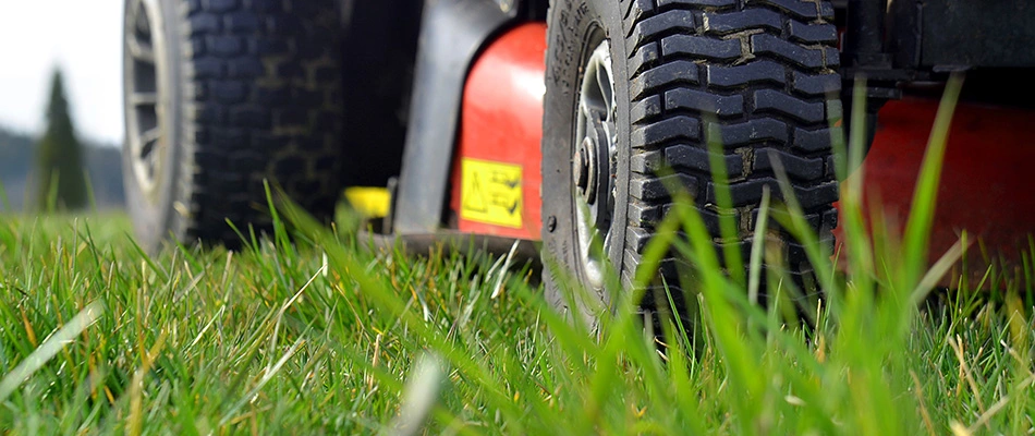 Close up on a lawn mower in action on an unkept lawn by a home in Noblesville, IN. 